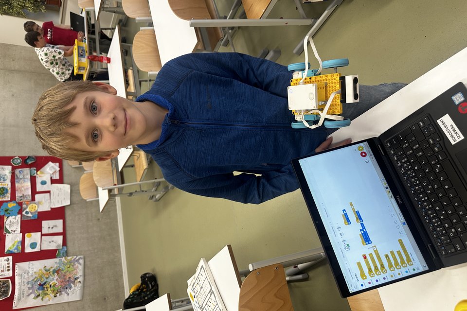Starší dítě u robota ze SPIKE™ Prime s tabletem a programem ve SCRATCHi